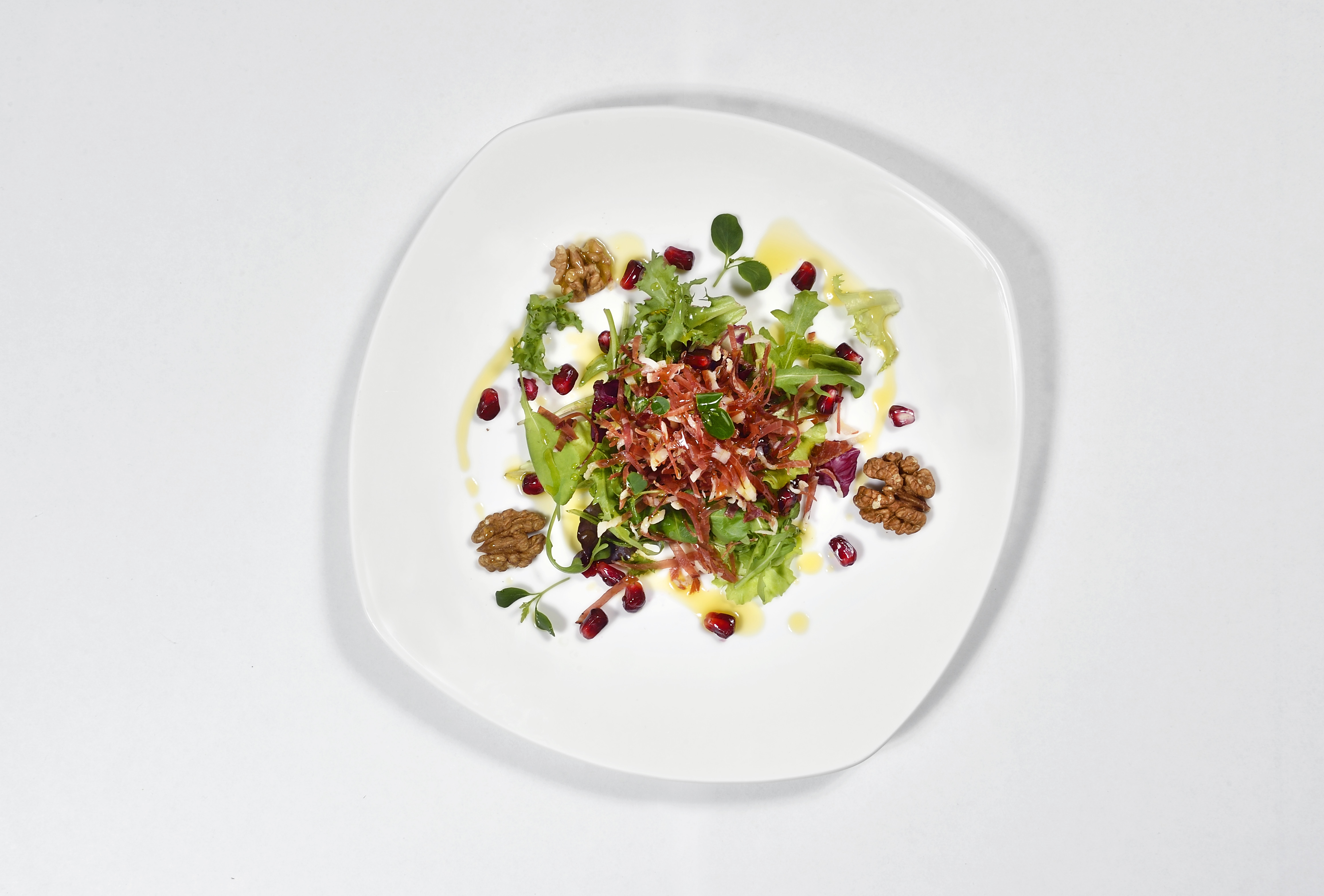 Bouquet of mixed leaf lettuce with pomegranate pearls, crunchy filets of speck and walnuts 1